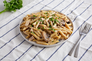 Homemade One-Pot Creamy Chicken Marsala Pasta with Parsley on a Plate, side view.