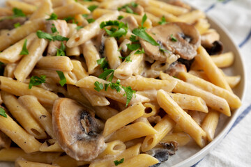 Homemade One-Pot Creamy Chicken Marsala Pasta with Parsley on a Plate, side view. Close-up.