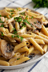Homemade One-Pot Creamy Chicken Marsala Pasta with Parsley on a Plate, side view. Close-up.
