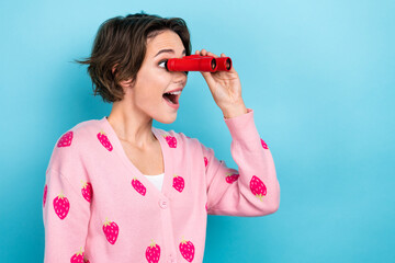 Profile photo of astonished positive girl arm hold vintage binoculars look empty space ad isolated...