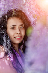 Woman wisteria lilac dress. Thoughtful happy mature woman in purple dress surrounded by chinese wisteria