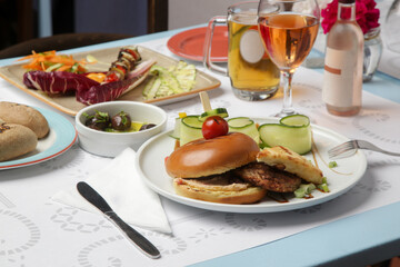 Fine casual dining: classic burger with cucumber slices served on the restaurant table	
