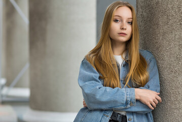 Portrait of a young blonde teen girl in a denim jacket. Lifestyle concept.