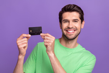 Photo of cheerful friendly nice man with stubble green t-shirt hands demonstrate debit plastic card...