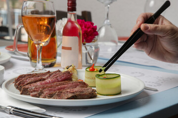 Chef in restaurant decorating dish, close up. Chef preparing meal for serving.