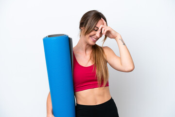 Young sport woman going to yoga classes while holding a mat isolated on white background laughing © luismolinero
