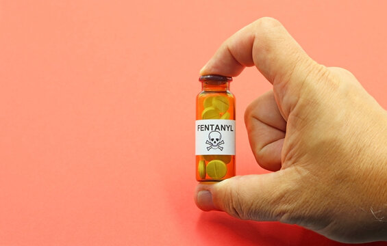 Hand showing a bottle of fentanyl pills, a powerful opioid that can cause death by overdose.