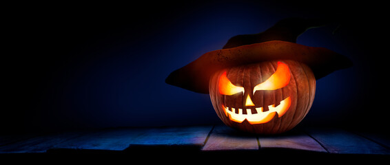 The spooky haunted evil glowing eyes of Jack O' Lanterns, halloween pumpkin, on the right of a...