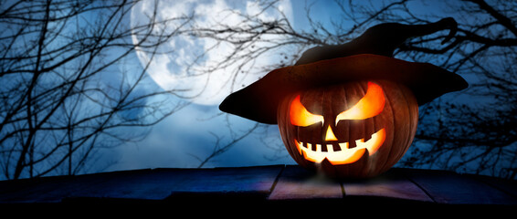 The spooky haunted evil glowing eyes of Jack O' Lanterns, halloween pumpkin, on the right of a...
