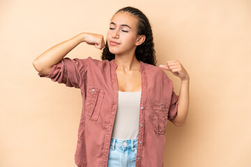 Young woman isolated on beige background doing strong gesture
