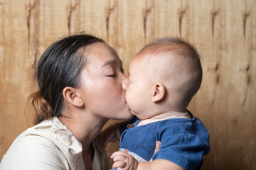 Mom kiss her cute baby boy