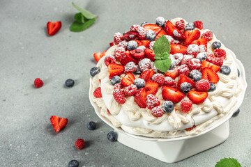 Pavlova cake with berries with topping with whipped cream and strawberries. culinary, bakery, food concept