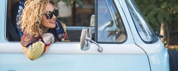 Banner image of young pretty woman traveler smile outside the window of her blue classic van...