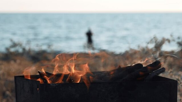Barbecue on beach or ocean. Inside there is fire flame, weekends, barbecue or grill. Caring for environment. Do not make fire on ground