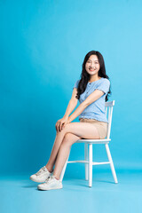 Portrait of smiling asian woman posing on blue background