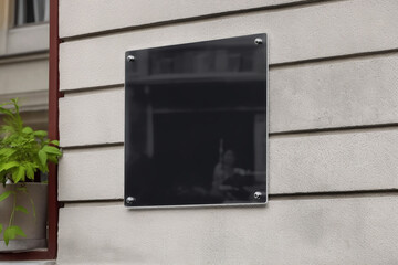 Blank black glass signplate on textured wall mockup