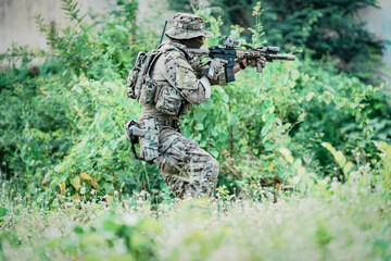 United States Army ranger during the military operation. Professional marine soldiers training with weapon on a military range.