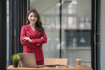 Beautiful Asian businesswoman standing with her arms crossed and looking at the camera.