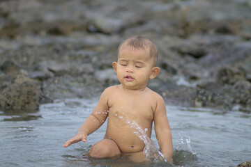 Rihan Husein Rohingya boy playing with water having shower beach