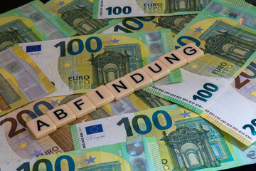 Symbolbild Abfindung: Buchstaben auf Euroscheinen zeigen das Wort Abfindung an