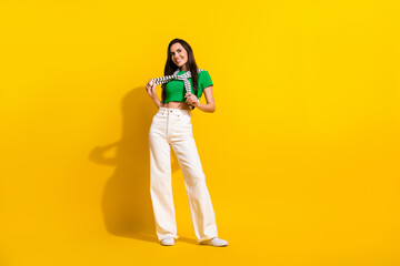 Fototapeta premium Full body portrait of charming cute girl model advertising outdoors street clothes posing camera isolated yellow color background