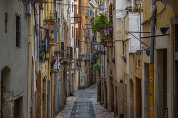 Narrow historic street with plants on balconies in Tarragona, Spain