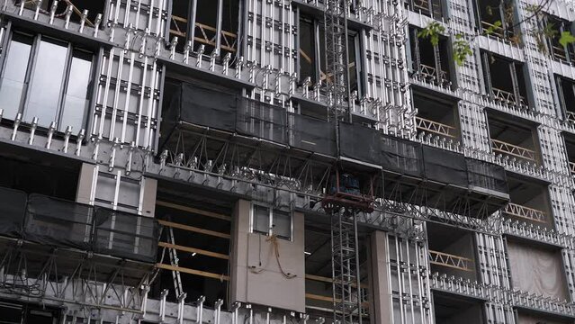 Building structures for facade cladding. Close-up of the process of facing a multi-storey building. Modern construction site.