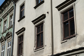 Facade of old tenement houses in Poland. Historical old town residential architecture. Building windows.
