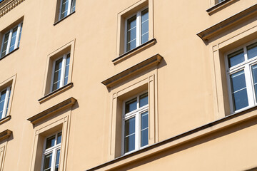 Facade of old tenement houses in Poland. Historical old town residential architecture. Building windows.