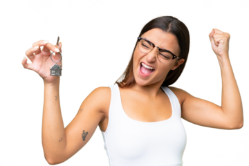 Young caucasian woman holding home keys isolated on green chroma background celebrating a victory