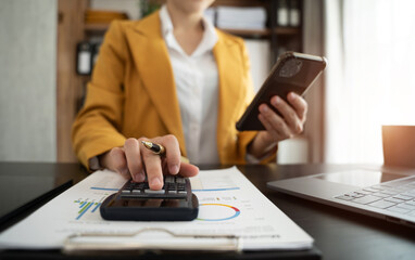 Fototapeta premium Hand women doing finances and calculate on desk about cost at home office.