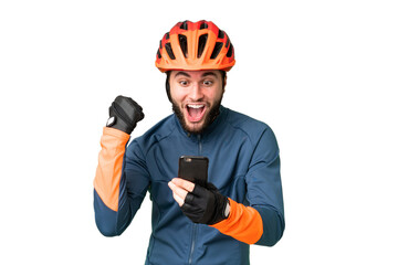 Young cyclist man over isolated chroma key background surprised and sending a message - obrazy, fototapety, plakaty