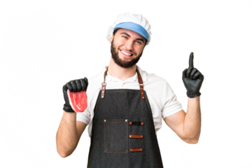 Butcher man wearing an apron and serving fresh cut meat over isolated chroma key background showing and lifting a finger in sign of the best