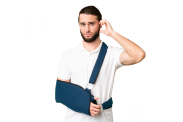 Young handsome man with broken arm and wearing a sling over isolated chroma key background having doubts