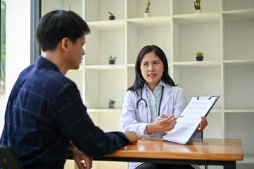 A serious Asian female doctor is in the examination room with a patient for a medical checkup