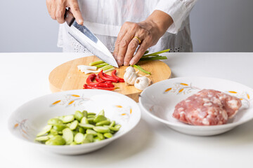 Asian elderly woman preparing Thai food ingredients in the kitchen