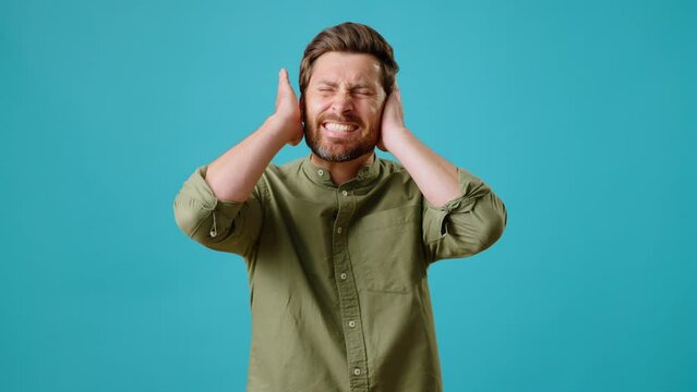 Male covers ears and shakes head hearing unpleasant sound