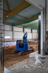 the floor of a newly built factory hall is excavated with an excavator