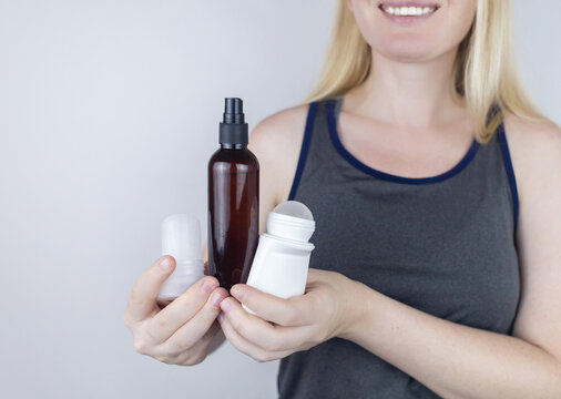 Girl holds in her hands three eco-friendly antiperspirants with natural ingredients. Refusal of antiperspirants containing toxic substances. Freedom from Aluminum chlorohydrate, alcohol, parabens