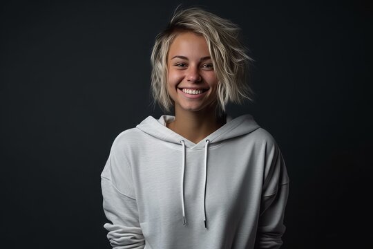 Portrait of a beautiful girl in a white sweatshirt on a dark background