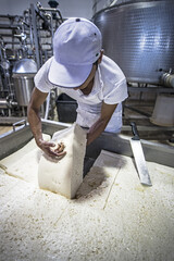 Fresh made italian cheese ricotta in a salt water bath top view.
Process of making fresh white soft ricotta whey cheese early morning on small cheese farm in Sicily, Italy.
