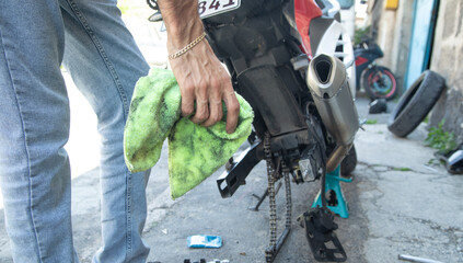 Biker man cleaning motorcycle. Maintenance, repair motorcycle