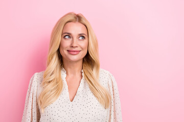 Portrait of good mood stunning woman with curly hairdo wear white dress look at proposition empty space isolated on pink color background