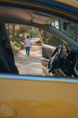 Fototapeta premium Latino man getting out of a vehicle on a forest road