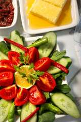 Traditional Turkish Breakfast served with traditional turkish tea on marble table, sliced tomato for breakfast