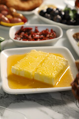 Traditional Turkish Breakfast served with traditional turkish tea on marble table, honey clotted cream for breakfast