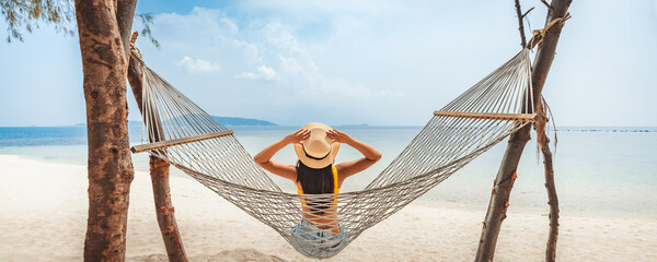 Traveler asian woman relax and travel in hammock on summer beach at Koh Rap Samui in Surat Thani Thailand