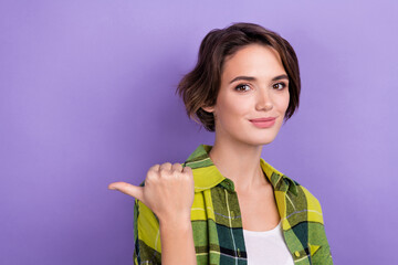 Portrait of friendly lovely lady indicate thumb finger empty space ad proposition blank isolated on purple color background