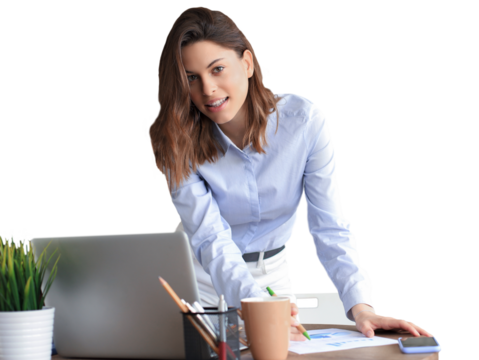 Confident young businesswoman with a friendly smile standing behind her desk looking at the camera on a transparent background