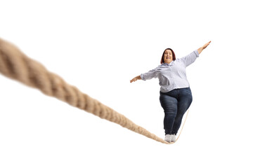 Full length portrait of a scared overweight woman walking on a rope